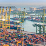 Container Cargo freight ship with working crane bridge in shipyard in singapore